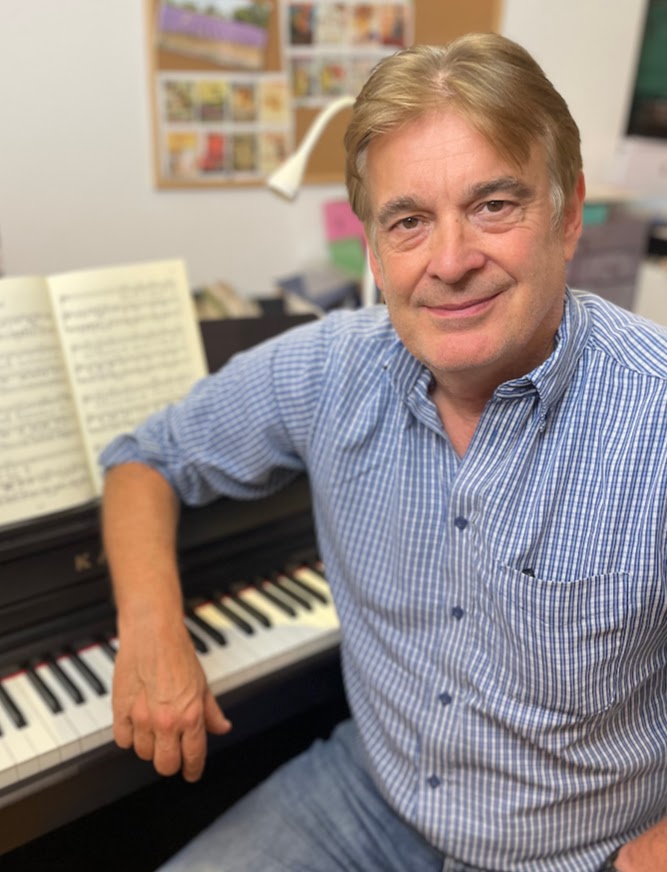 A musician sitting by a keyboard
